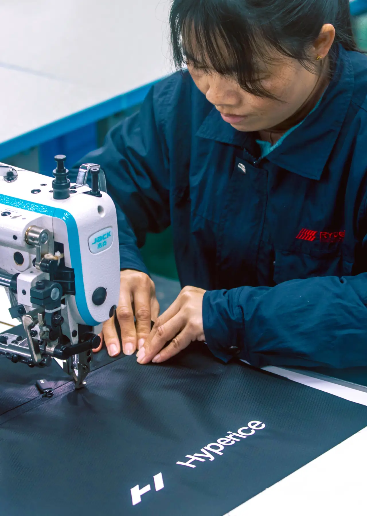 Close-up of hands guiding material under a sewing machine.